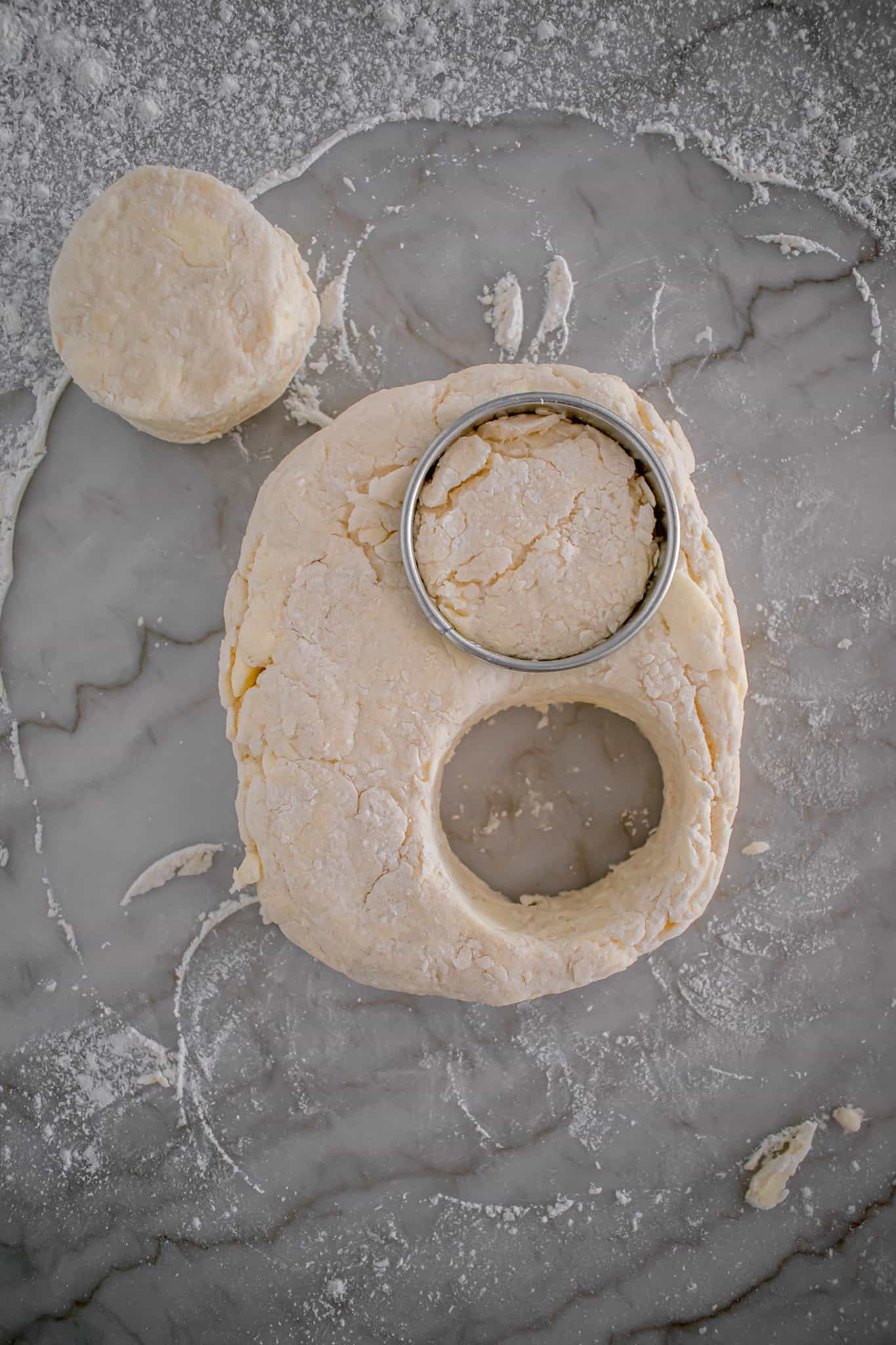 biscuit dough rolled out with biscuits being cut.