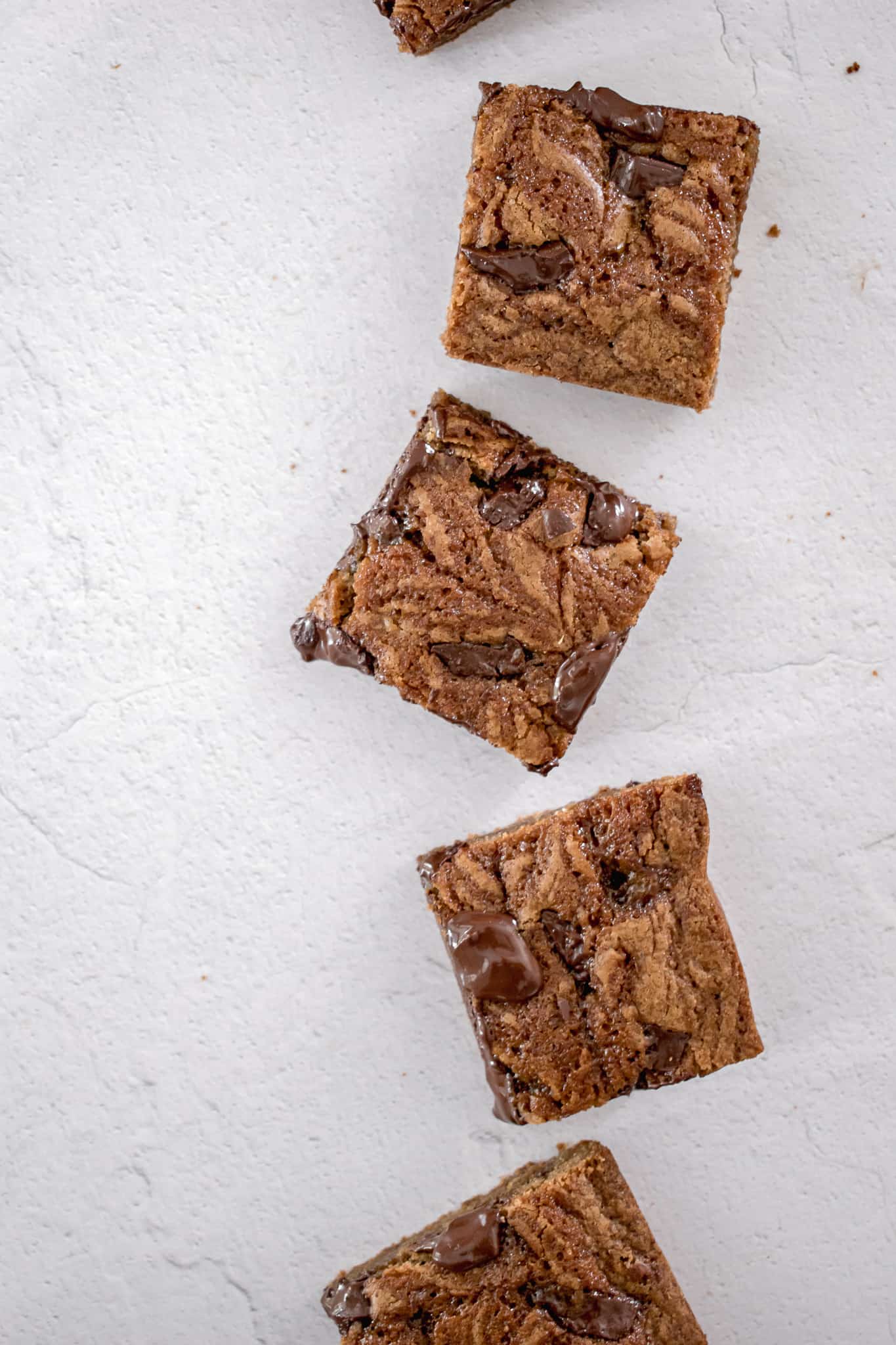 top view of a line of blondies on white background.