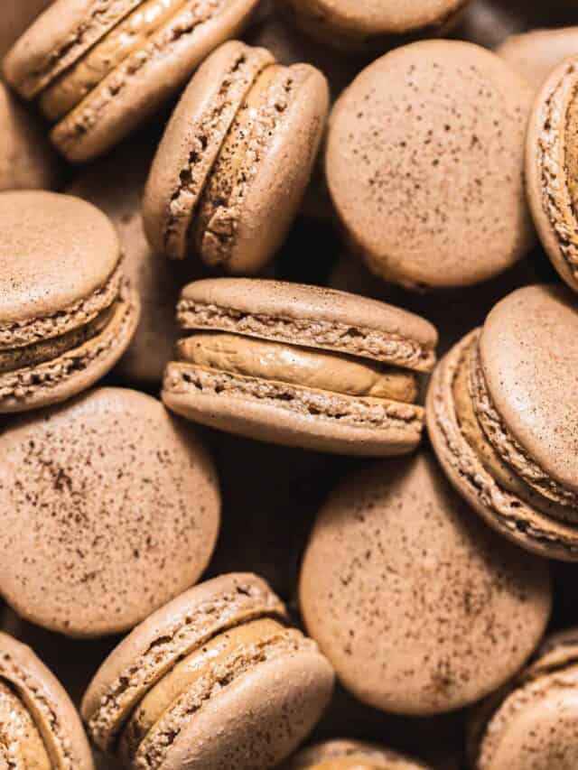 coffee macarons with french buttercream in a pile