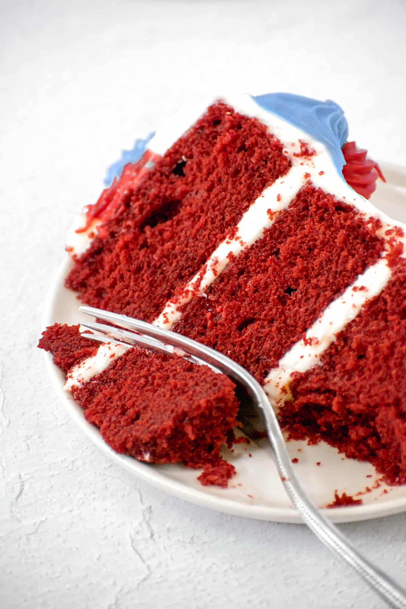 slice of red velvet layer cake with cream cheese frosting.