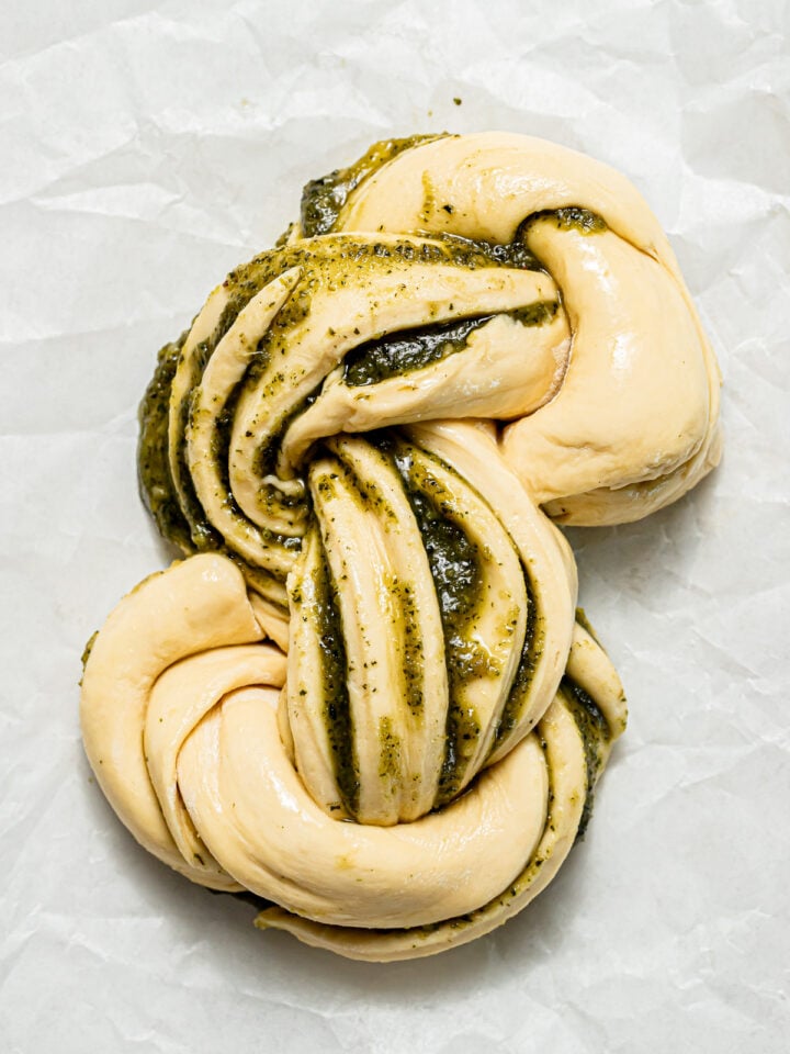 pesto swirl bread unbaked on parchment paper.