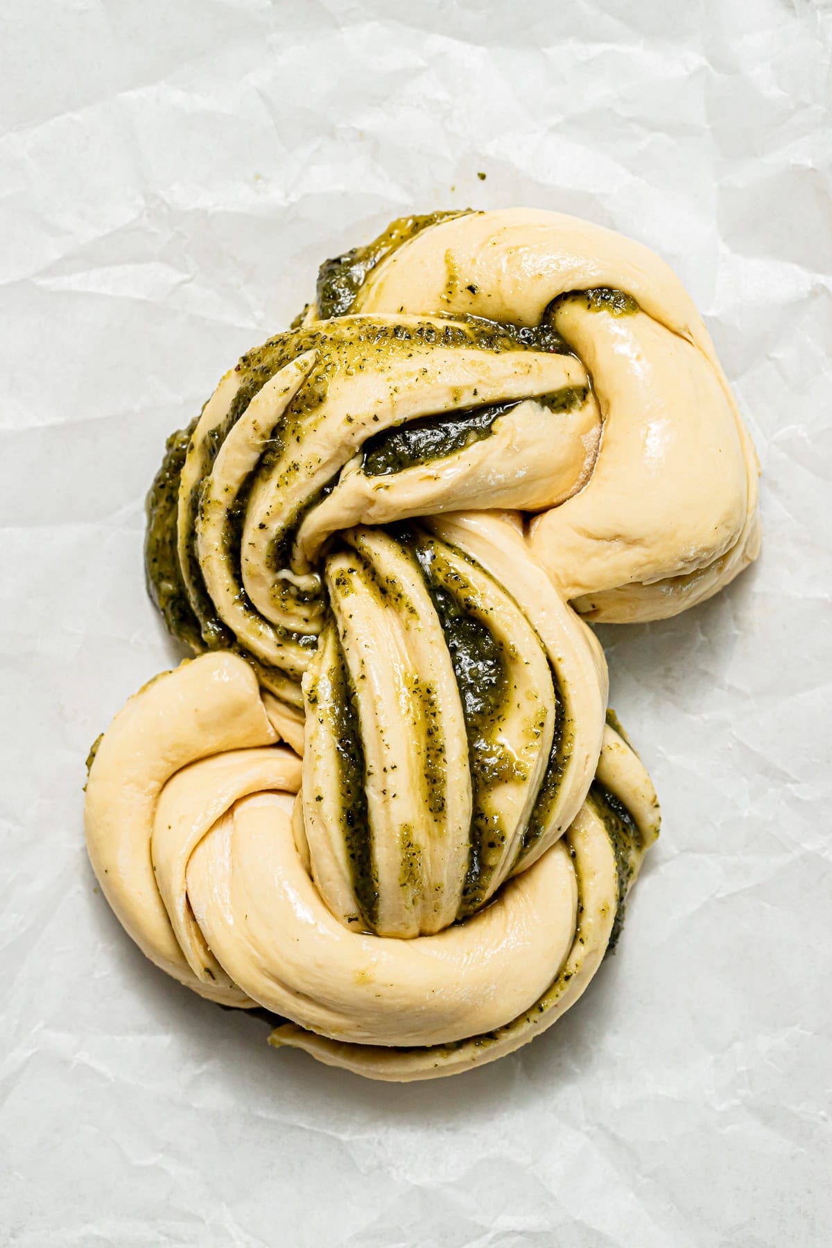 pesto swirl bread unbaked on parchment paper.