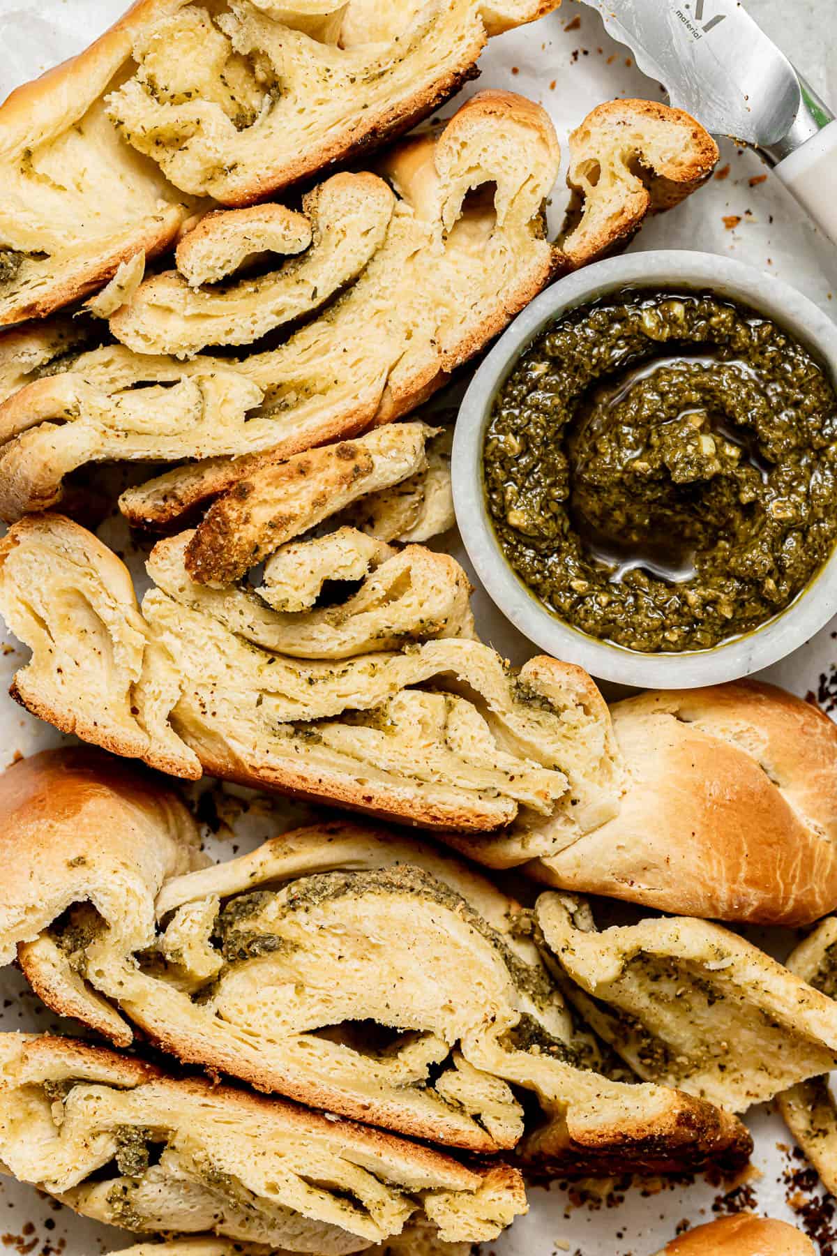 pesto bread cut into individual slices on baking sheet.