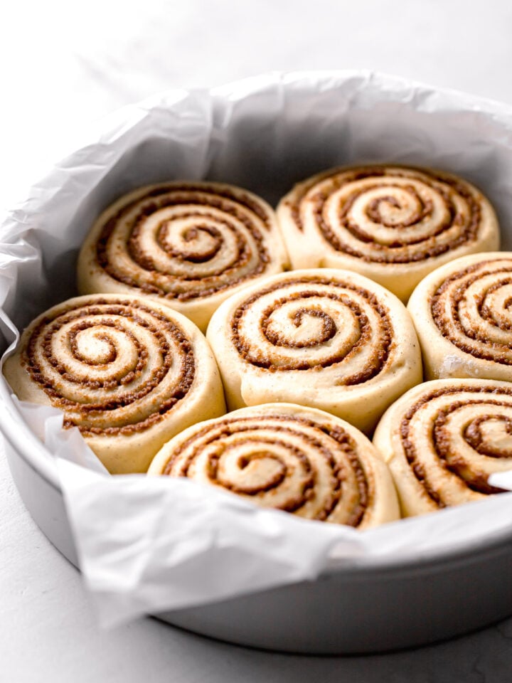 cardamom cinnamon rolls proofed in parchment lined cake pan