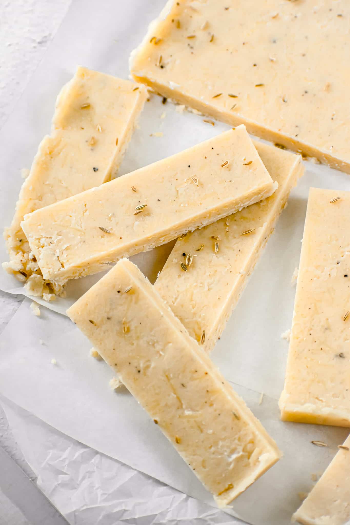 parmesan fennel shortbread stacked on parchment paper.