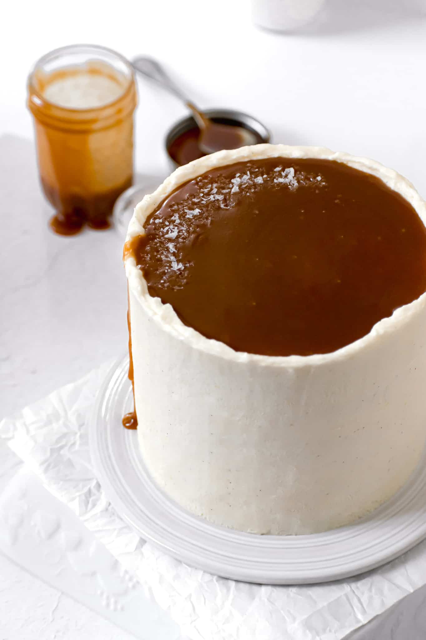 caramel layer cake with jar of caramel sauce in background.