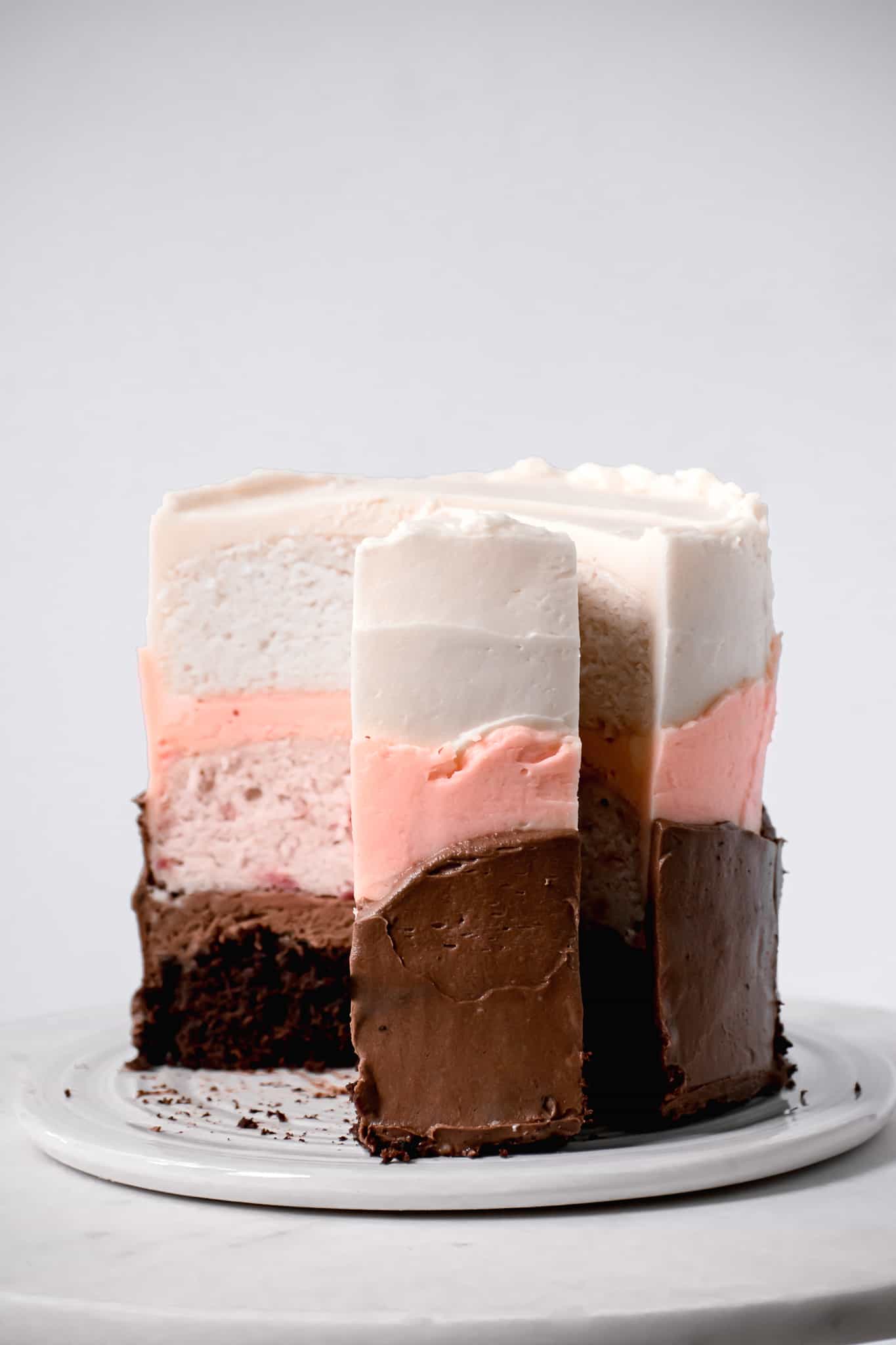 side view of neapolitan cake with one slice sticking out.