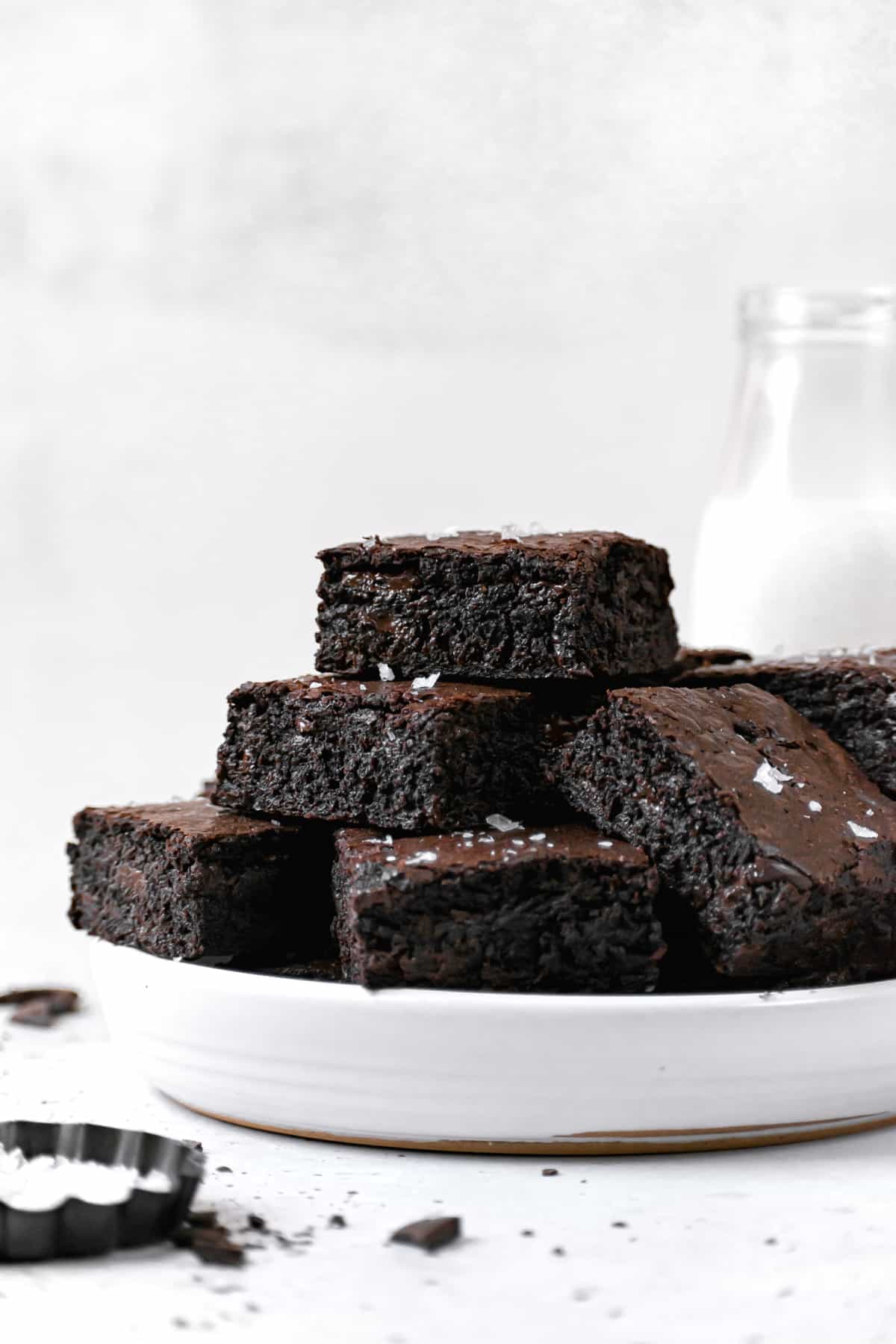 brown butter brownies piled on white plate.