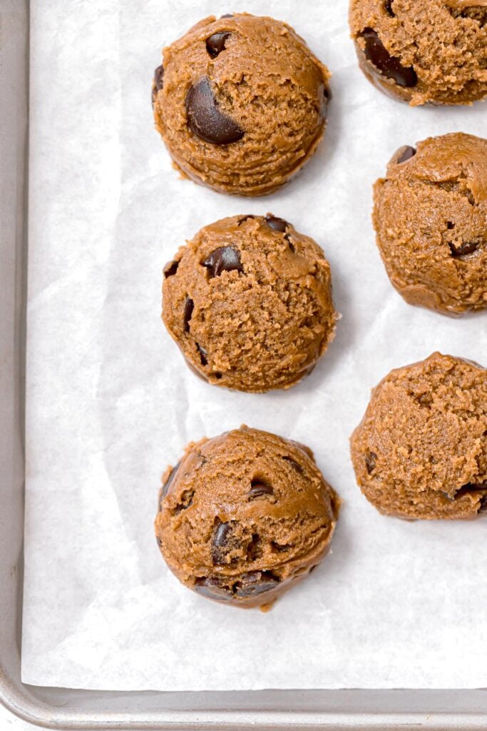 cookie dough balls on parchment lined baking sheet