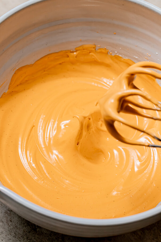 orange colored meringue in bowl.
