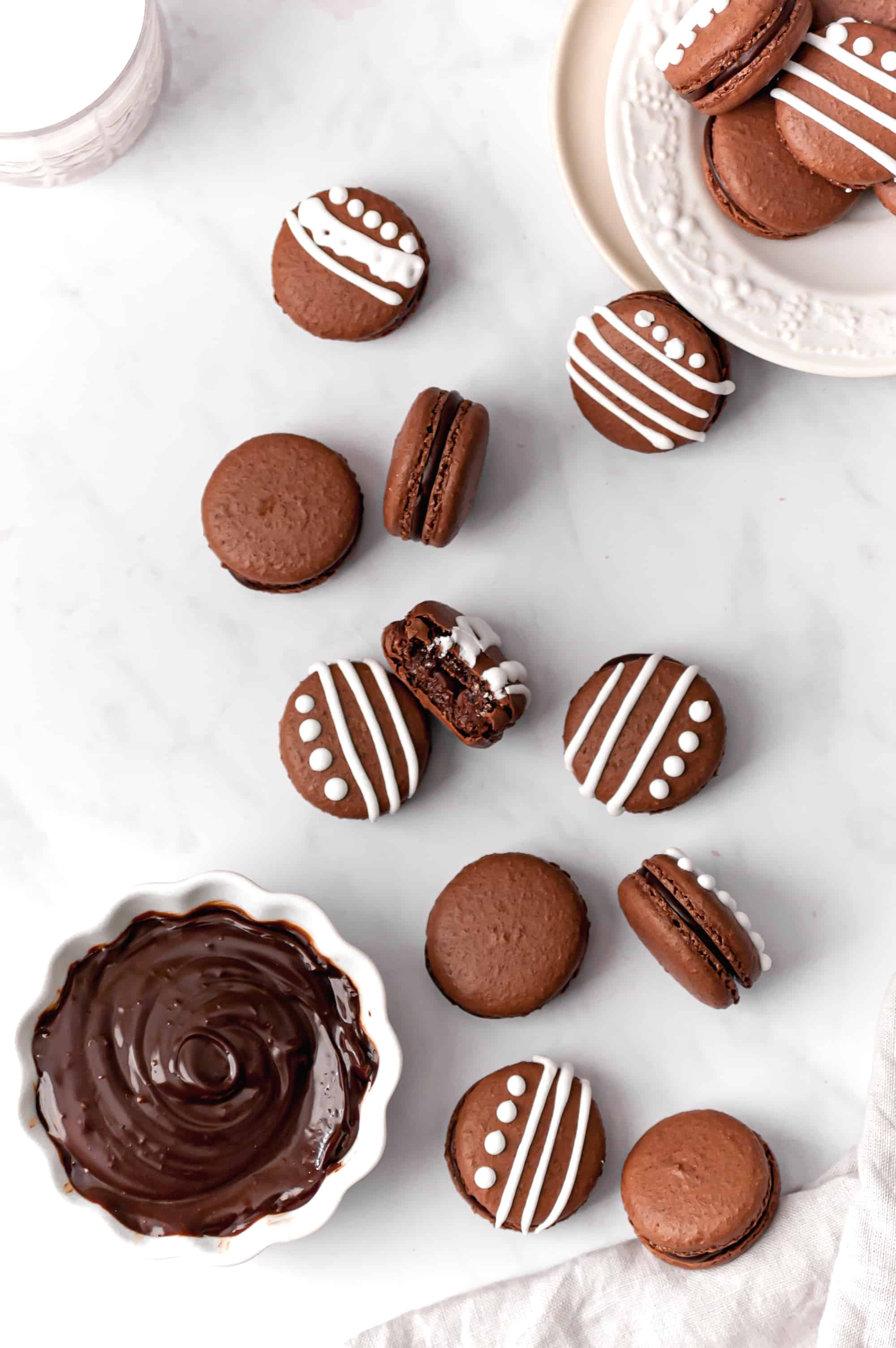 macarons on marble with chocolate peppermint ganache in small bowl