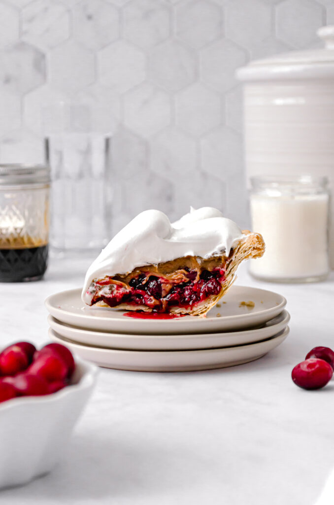 slice of ginger molasses cranberry pie on stack of plates