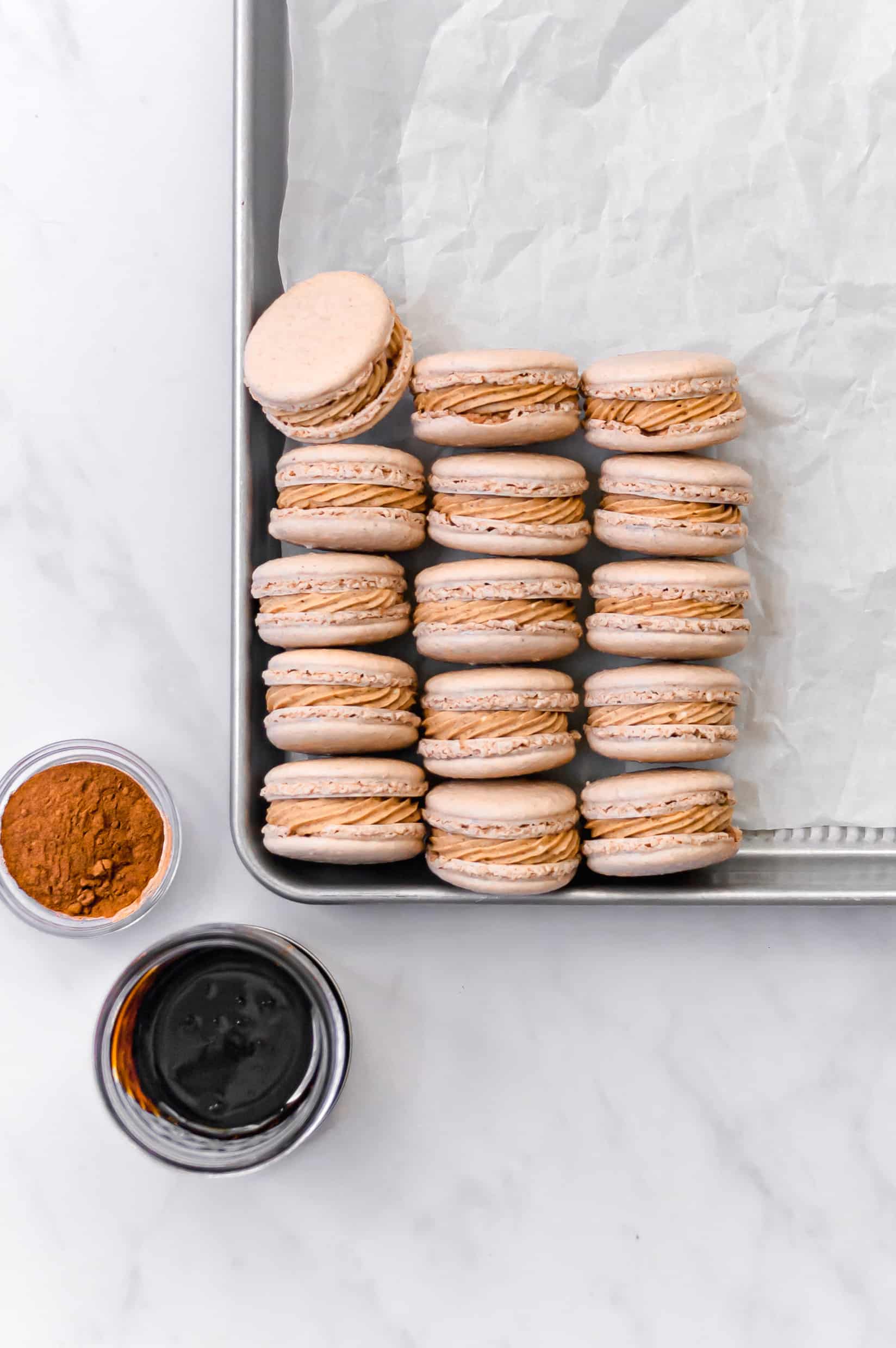 spiced macarons assembled neatly  on a baking tray.