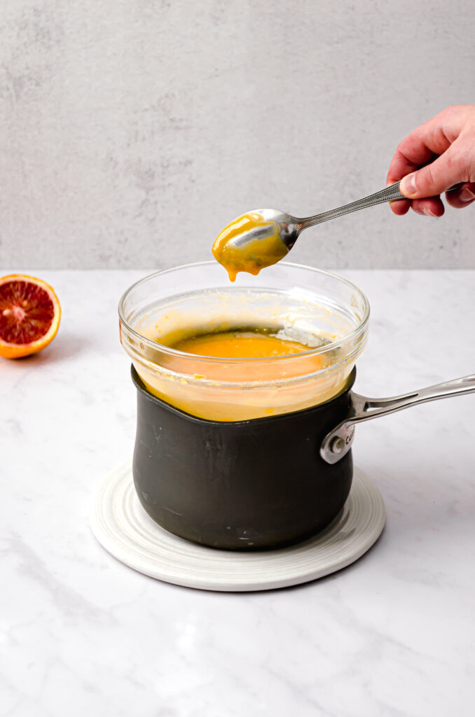 double boiler with blood orange curd and spoon