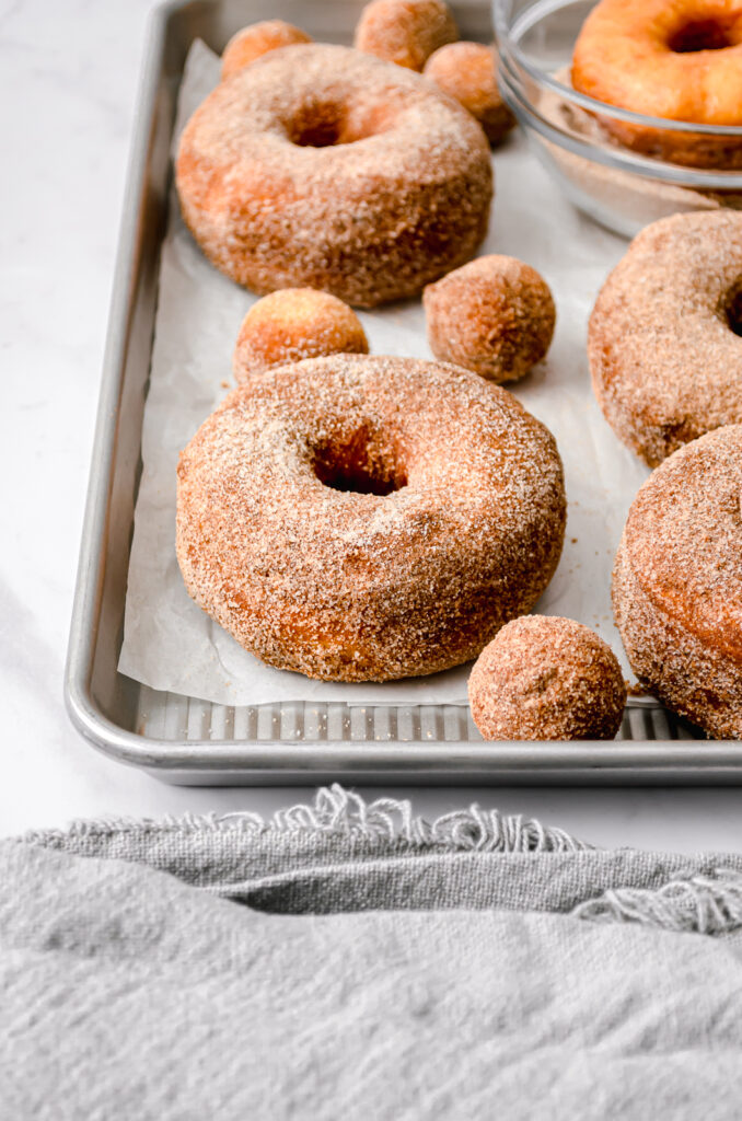 baked donuts on parchment paper lined baking sheet