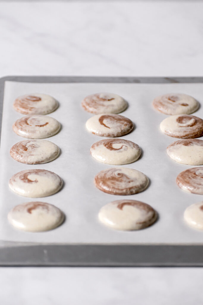 unbaked macarons on parchment lined baking sheet 