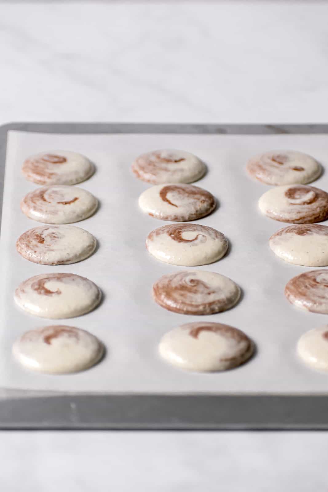 unbaked macarons on parchment lined baking sheet.