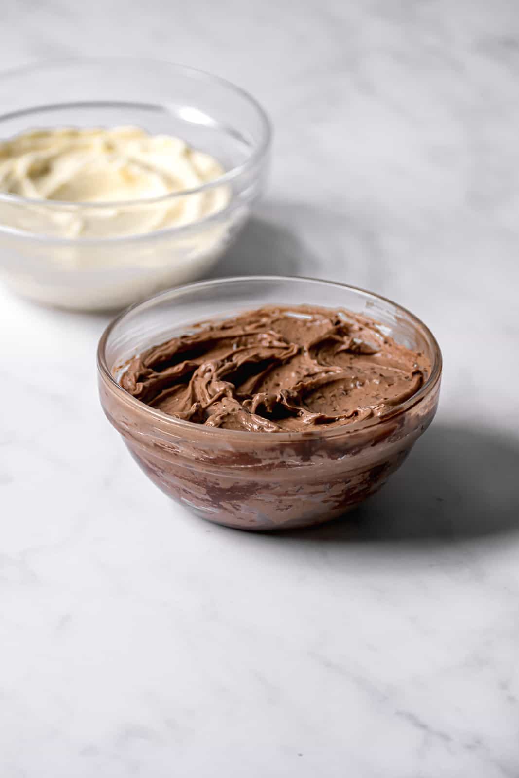 chocolate and vanilla swiss meringue buttercream in glass bowls.