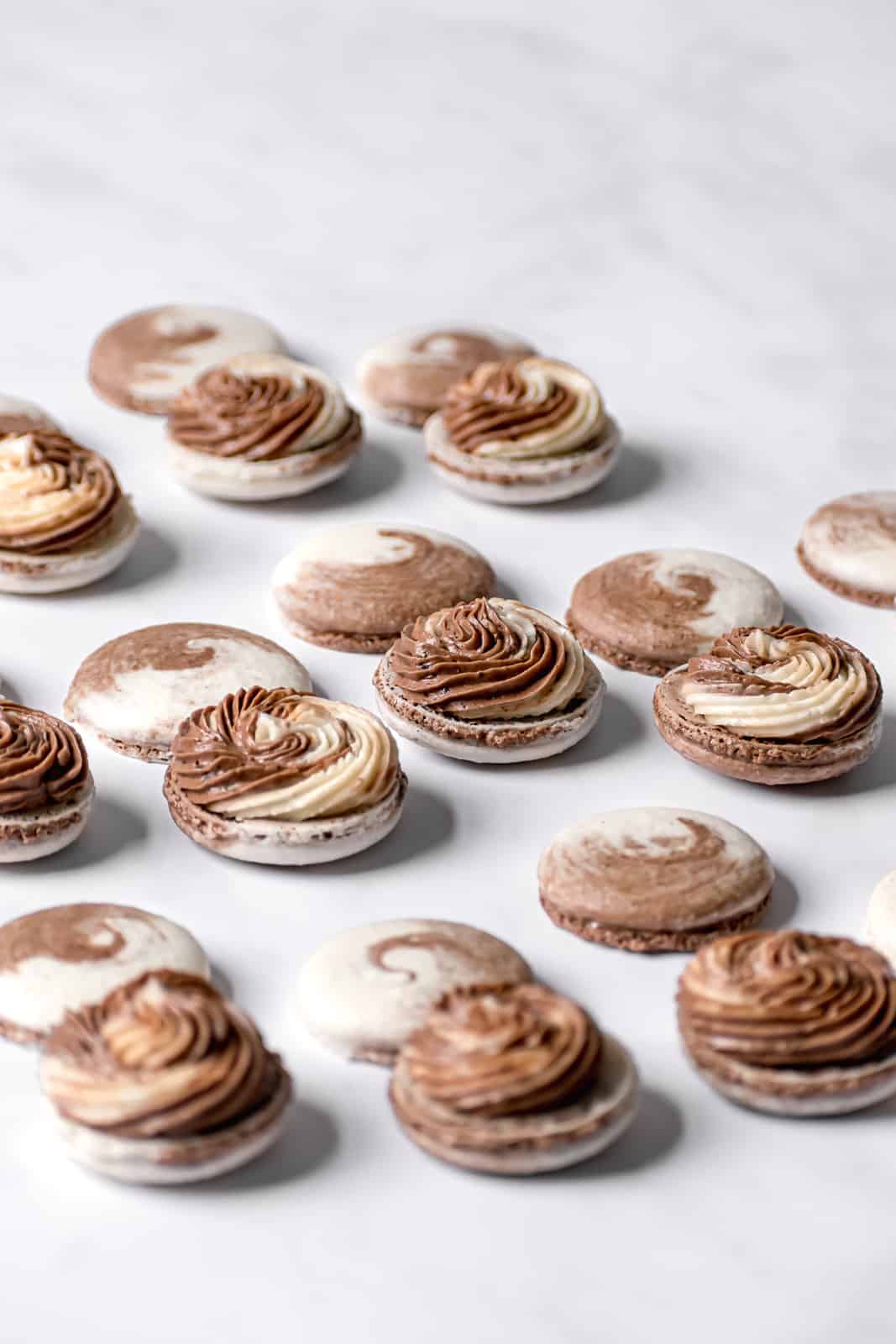Chocolate & Vanilla Swirled Macarons filled with swiss meringue buttercream on marble.