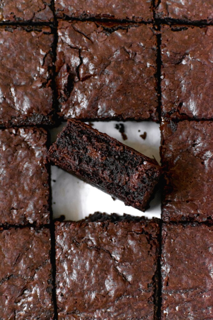 freshly cut brownies with center piece standing up to reveal fudgy texture