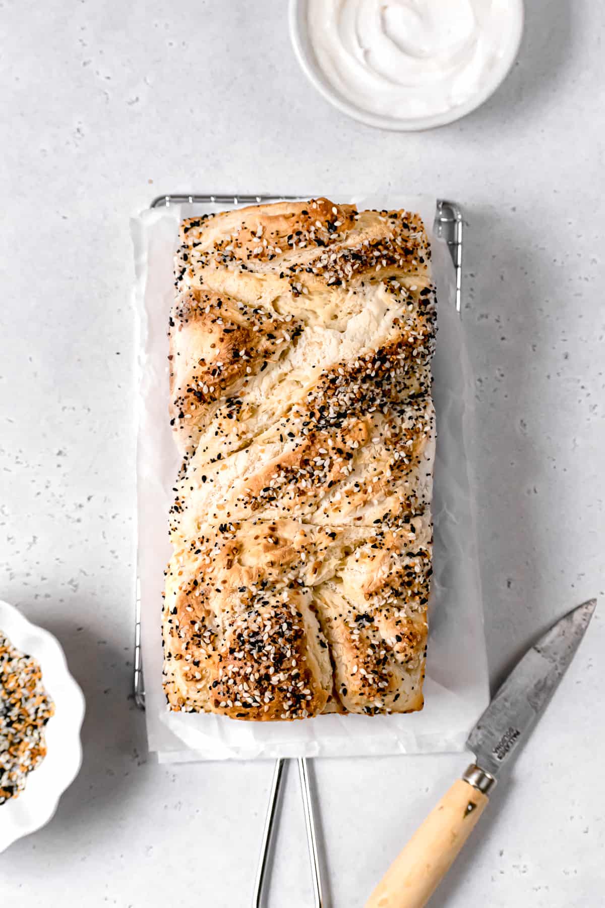 baked bagel babka in loaf pan with everything seasoning on top.