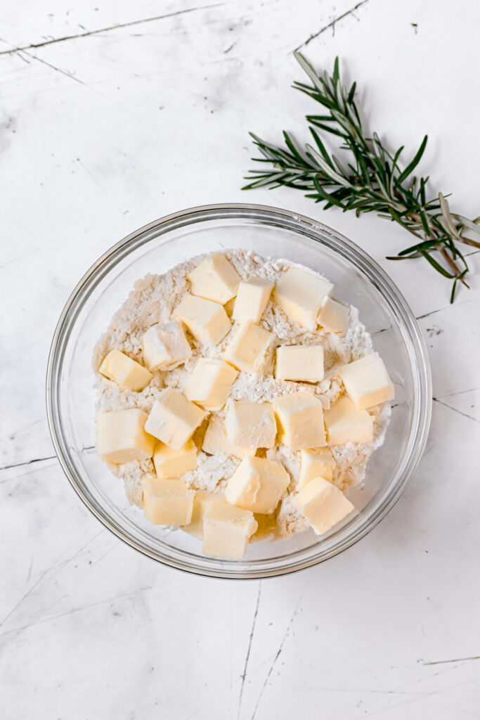 cold cubes of butter in flour in glass bowl