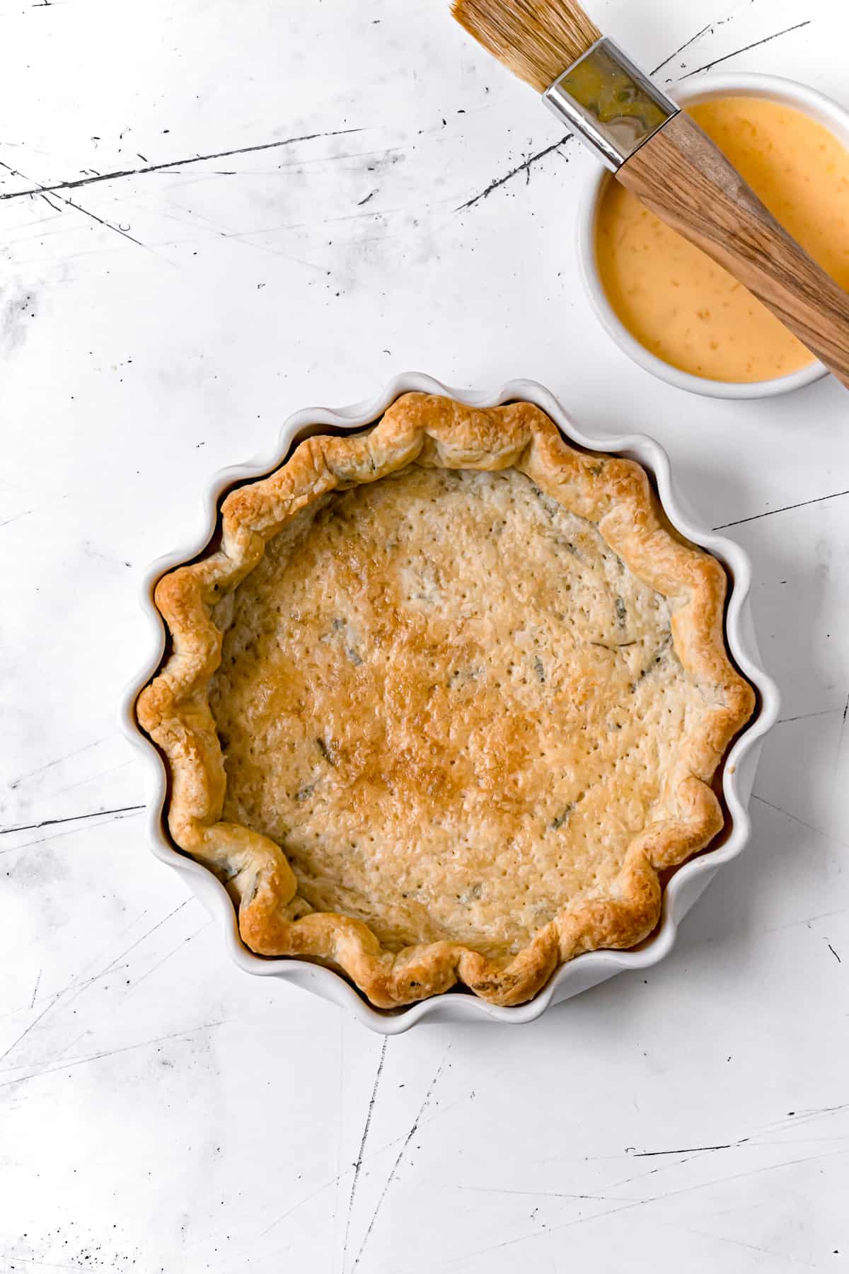 evenly golden blind baked pie crust in white pie dish.