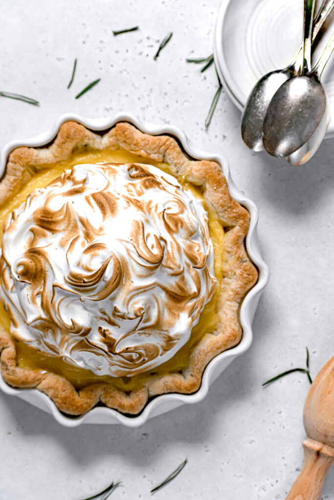 lemon meringue pie with fresh rosemary crust in white pie dish