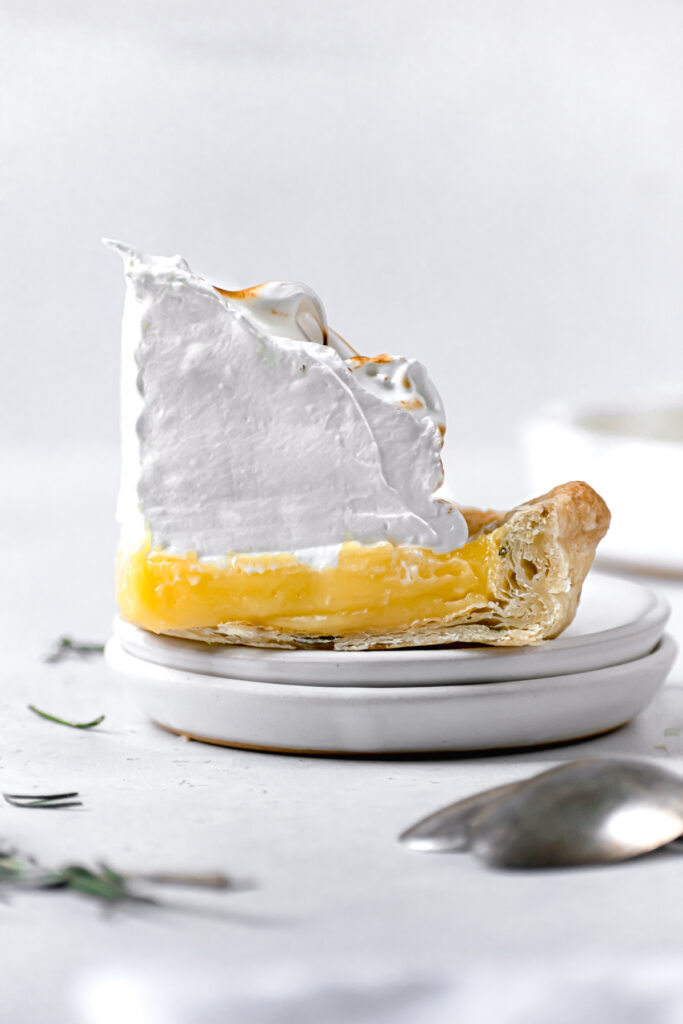 one piece of lemon rosemary meringue pie on white plate