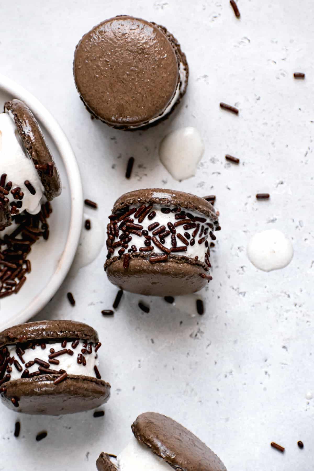 macaron ice cream sandwich with chocolate jimmy sprinkles on a white background.