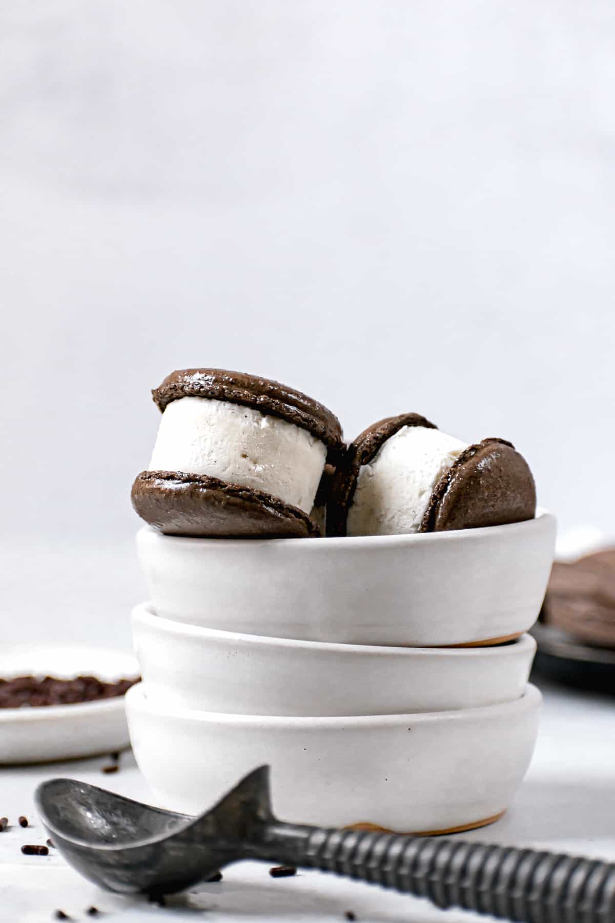 a few macarons in three stacked white bowls.