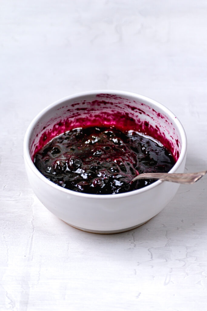 jammy blueberry filling in white bowl with spoon