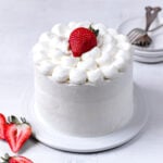 white cake with strawberries on white plate
