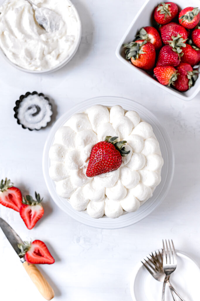 decorated cake on stand with fresh strawberries 