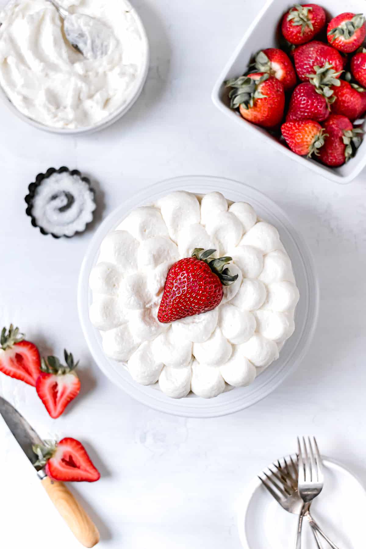 decorated cake on stand with fresh strawberries.