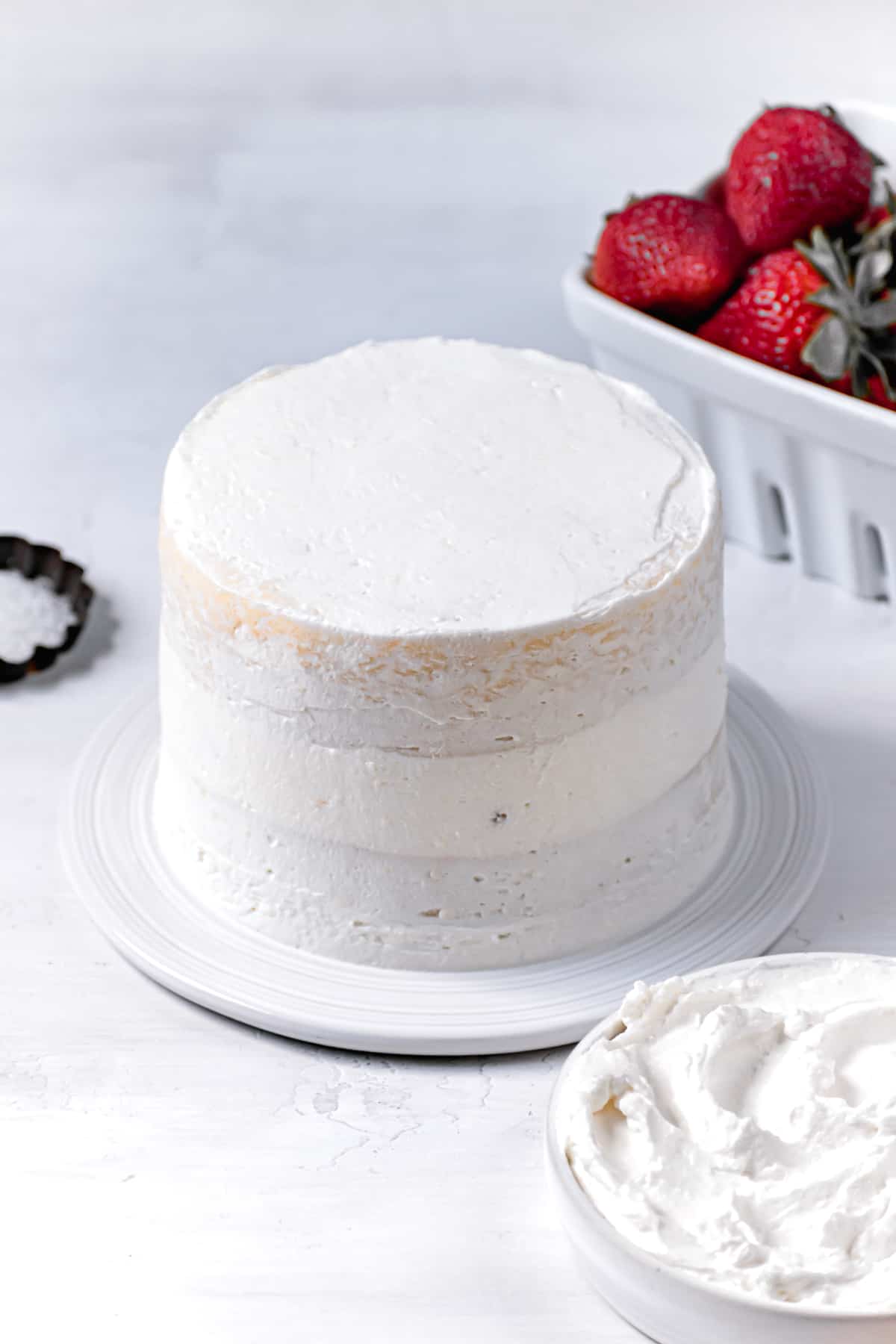 crumb coat of frosting spread all over cake.
