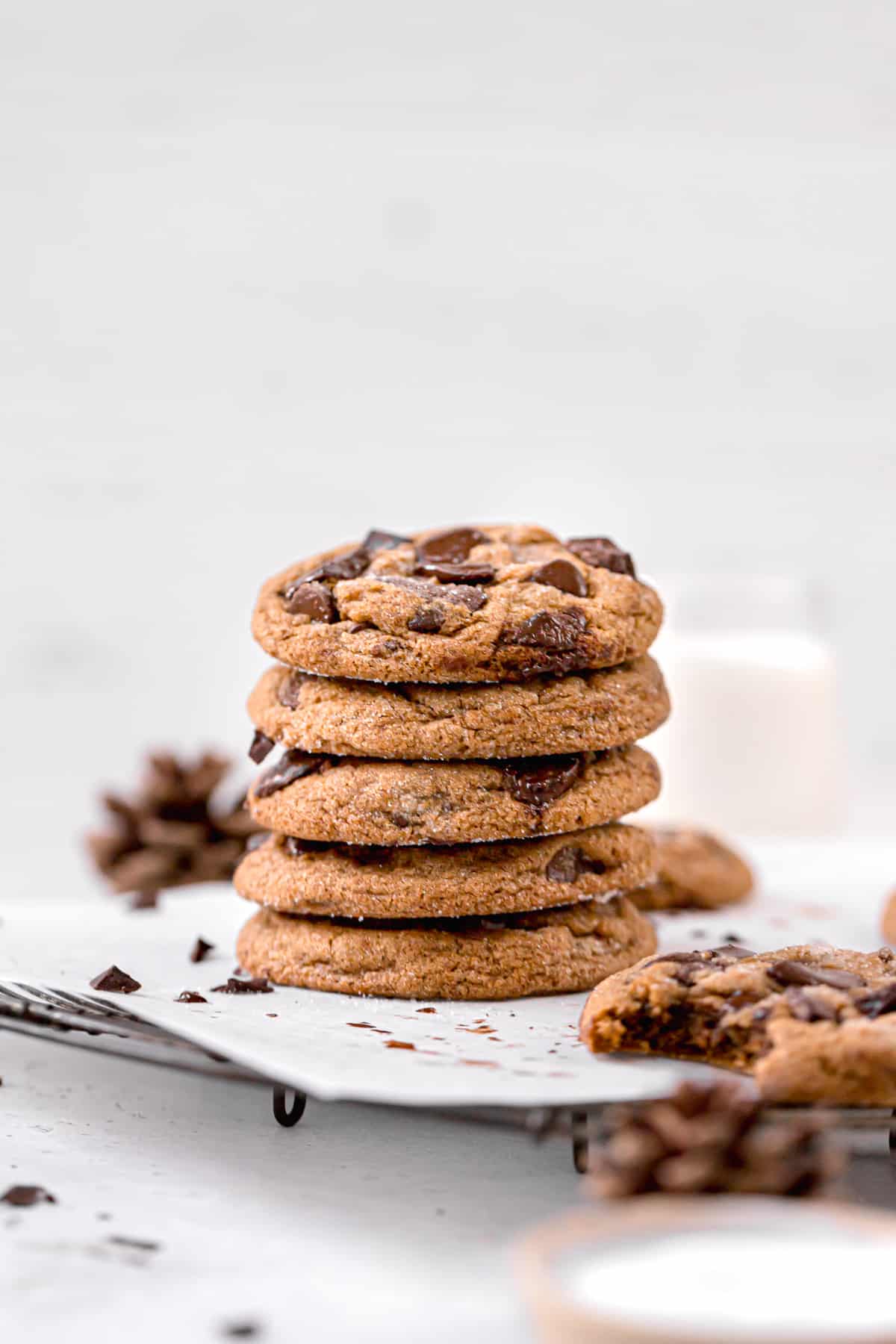 chocolate chip cookies with molasses stacked on round wire rack.