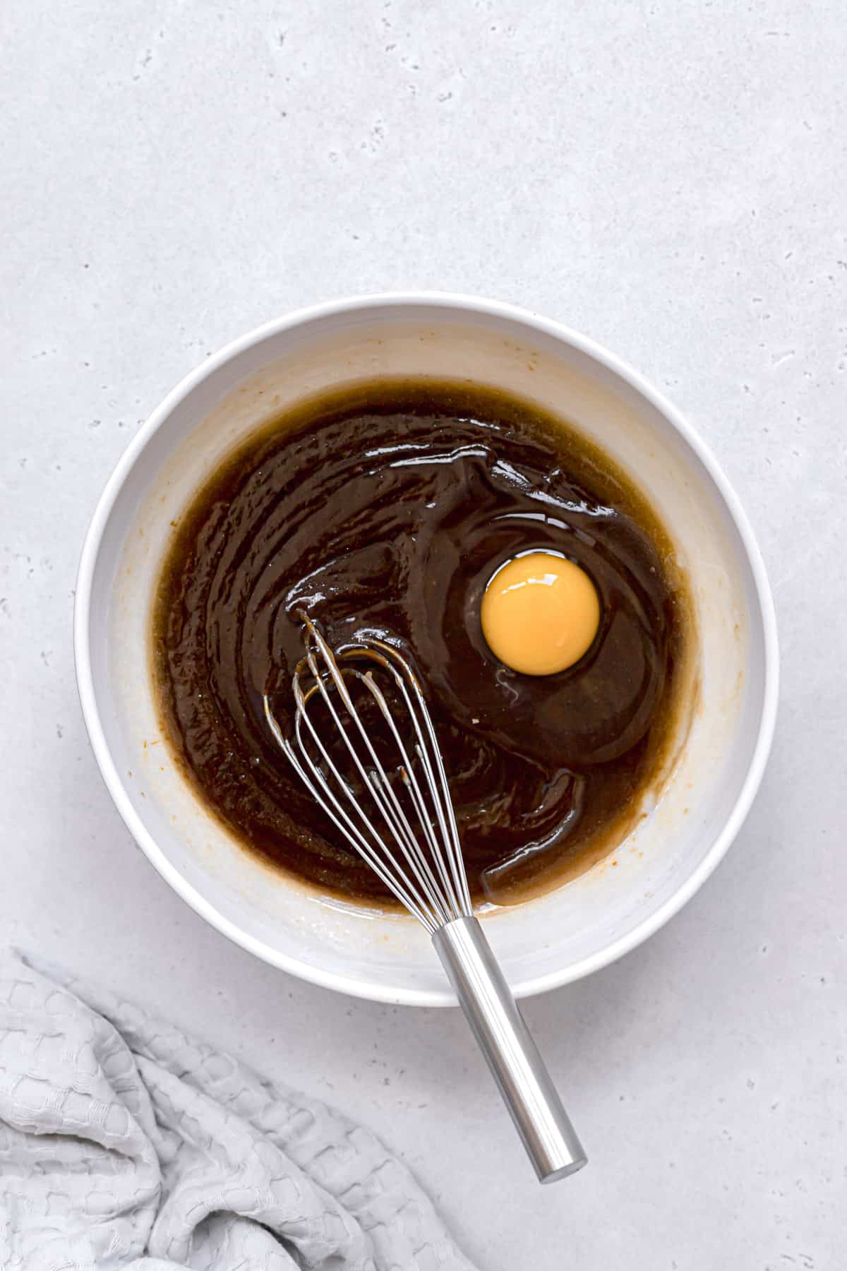 egg being whisked into wet ingredients.