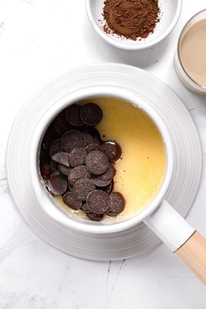 chocolate wafers on top of melted butter and sugar in white saucepan