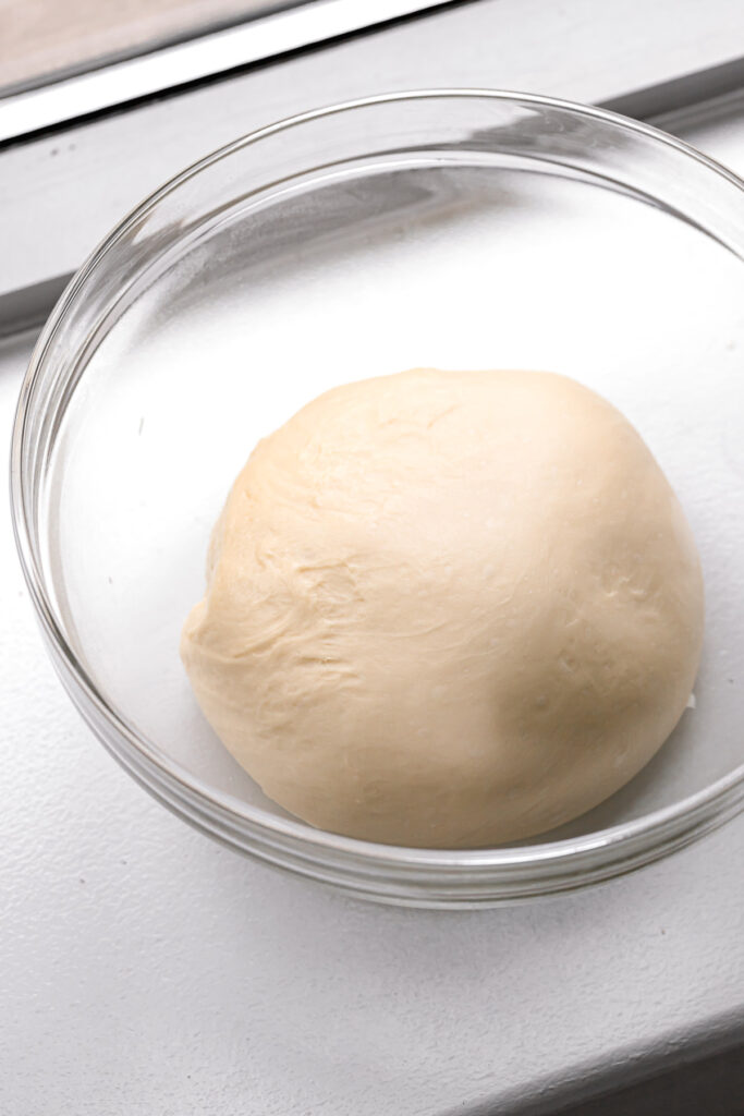 brioche dough in glass bowl 