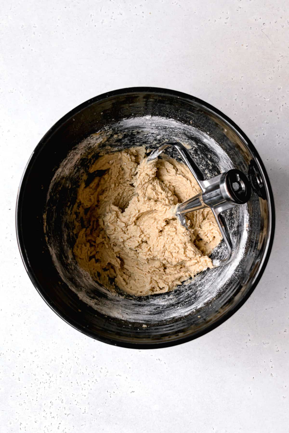 cookie dough in black mixing bowl.
