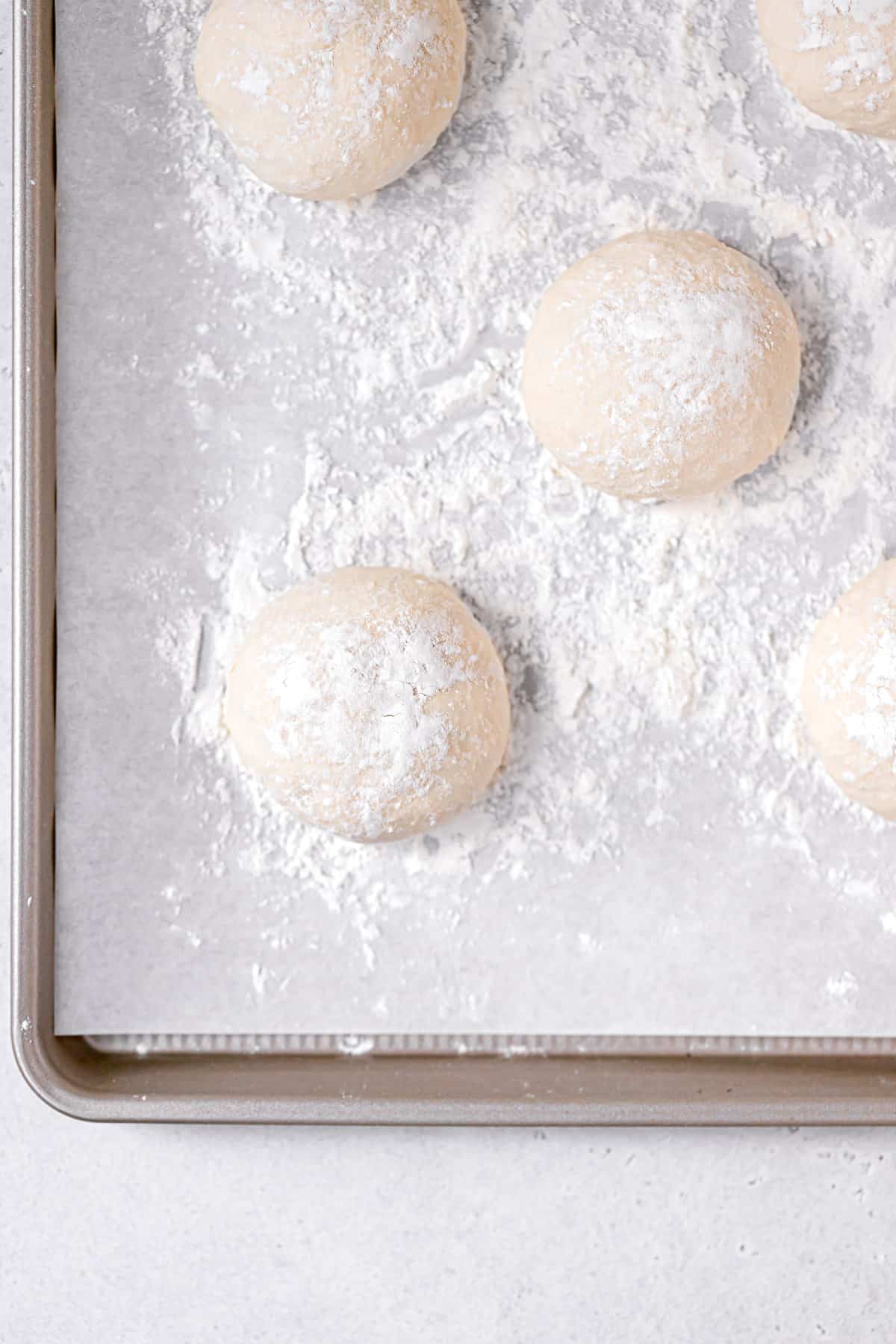 dough divided into 12 balls on baking sheet.