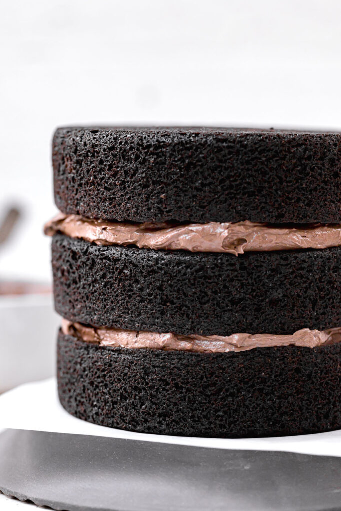 three dark velvet cake layers with buttercream in between