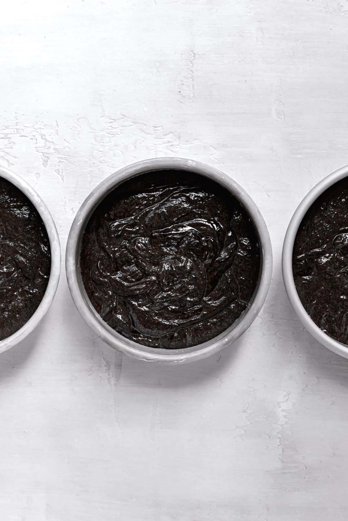 black cocoa cake batter in 6 inch cake pans.