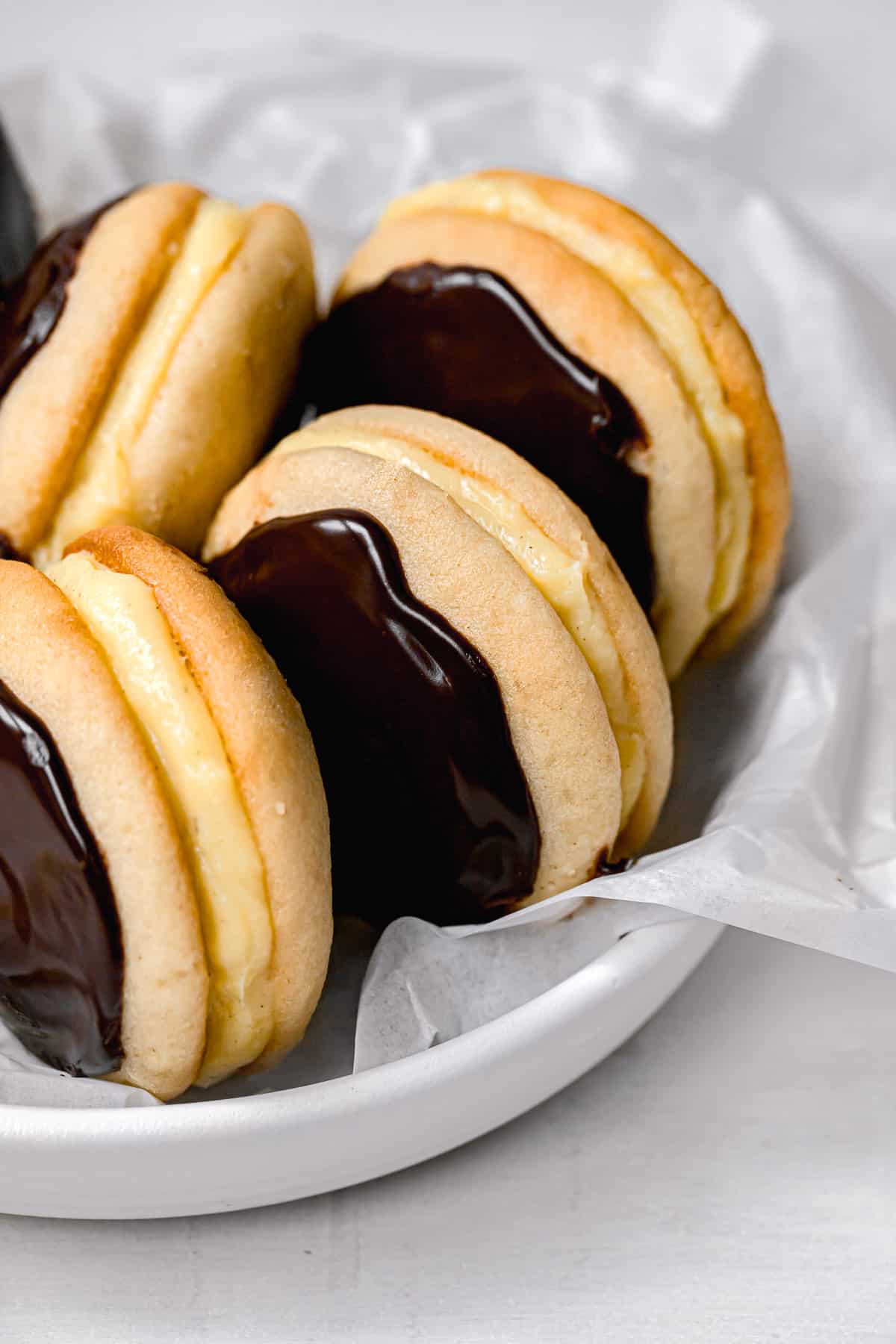 boston cream whoopie pies lined up in white bowl.