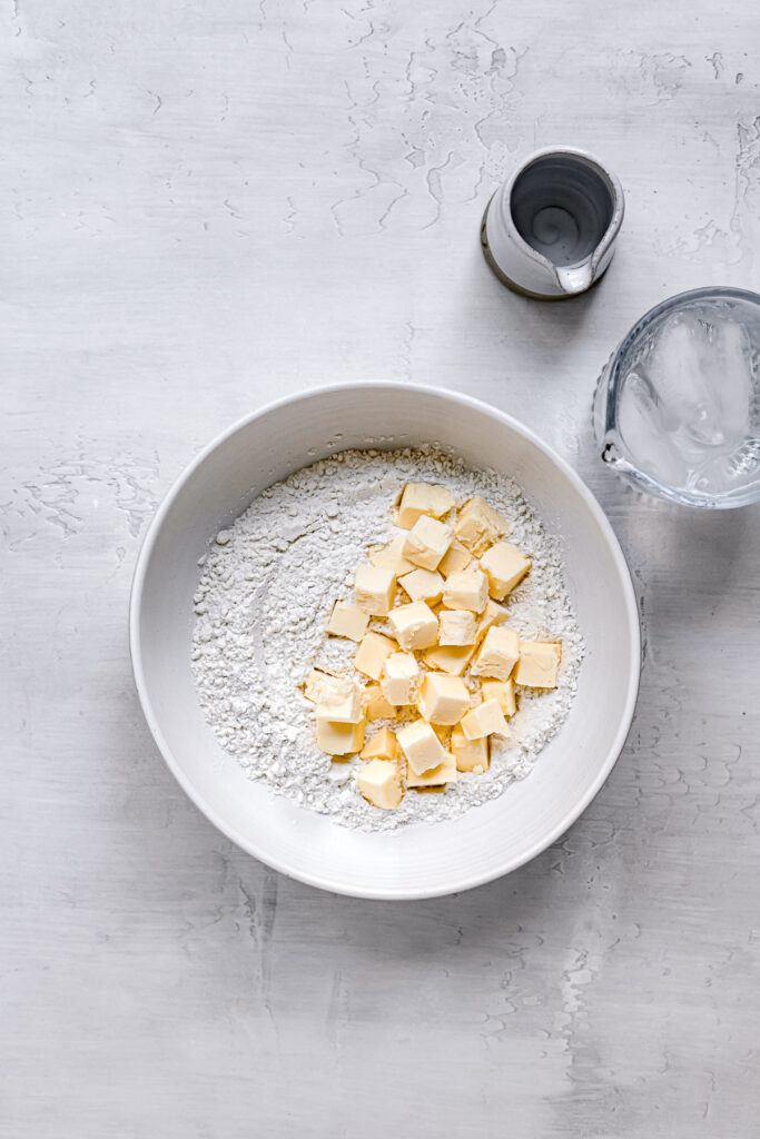 cold cubed butter with flour in white bowl