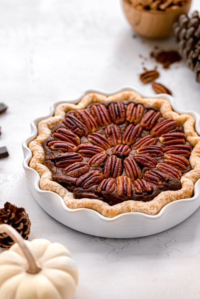 freshly baked chocolate brownie pie with pecans in white pie dish