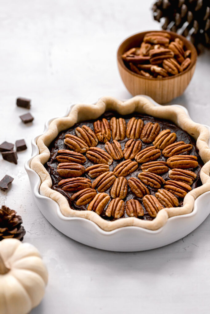 unbaked brownie pie with pecans on top