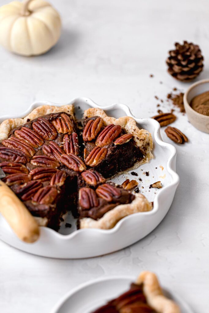 pecan brownie pie with slices cut in white pie dish