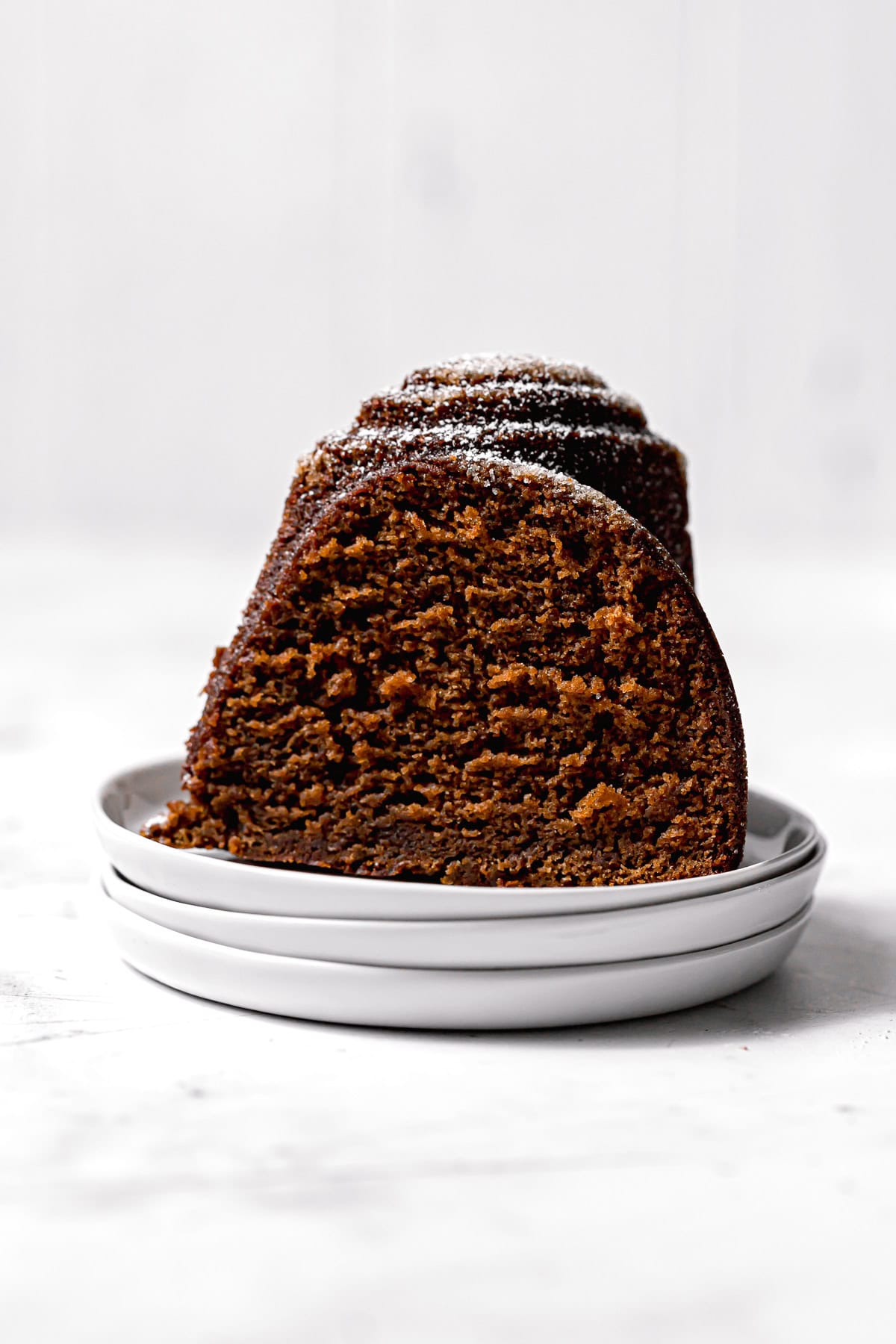 slice of gingerbread cake on stacked plates.